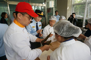 岳振東老師向學(xué)生們講解包粽子的方法